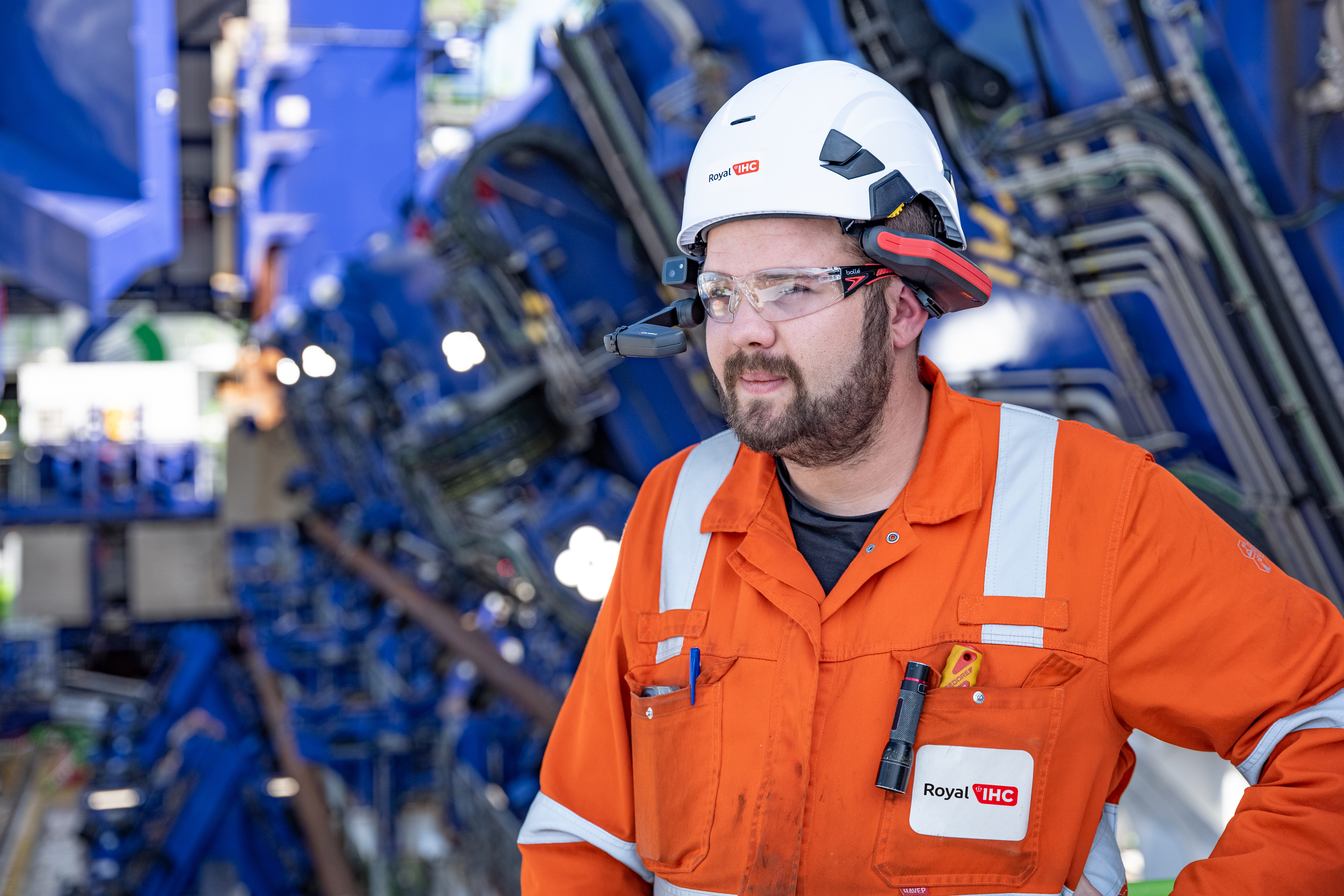 Guy in overall and helmet with smart glasses on ship