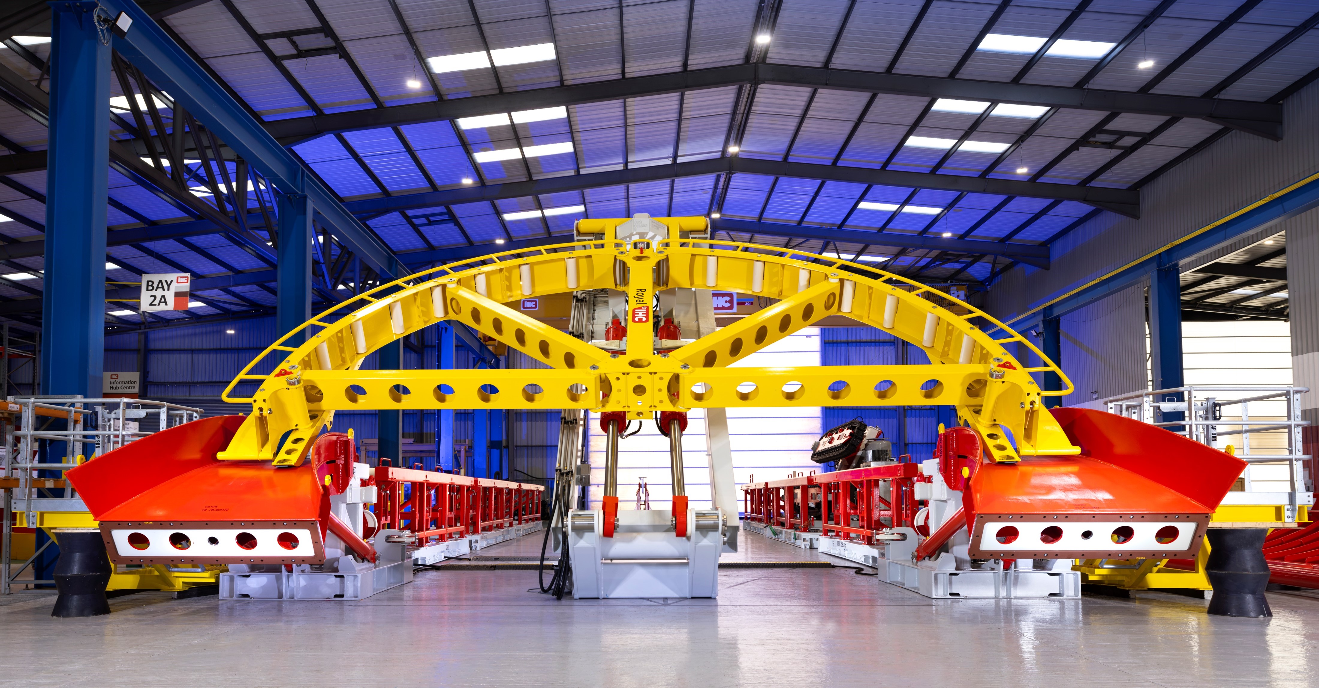Yellow quadrant tipping towards the camera, with red chutes either side. Inside a factory setting.