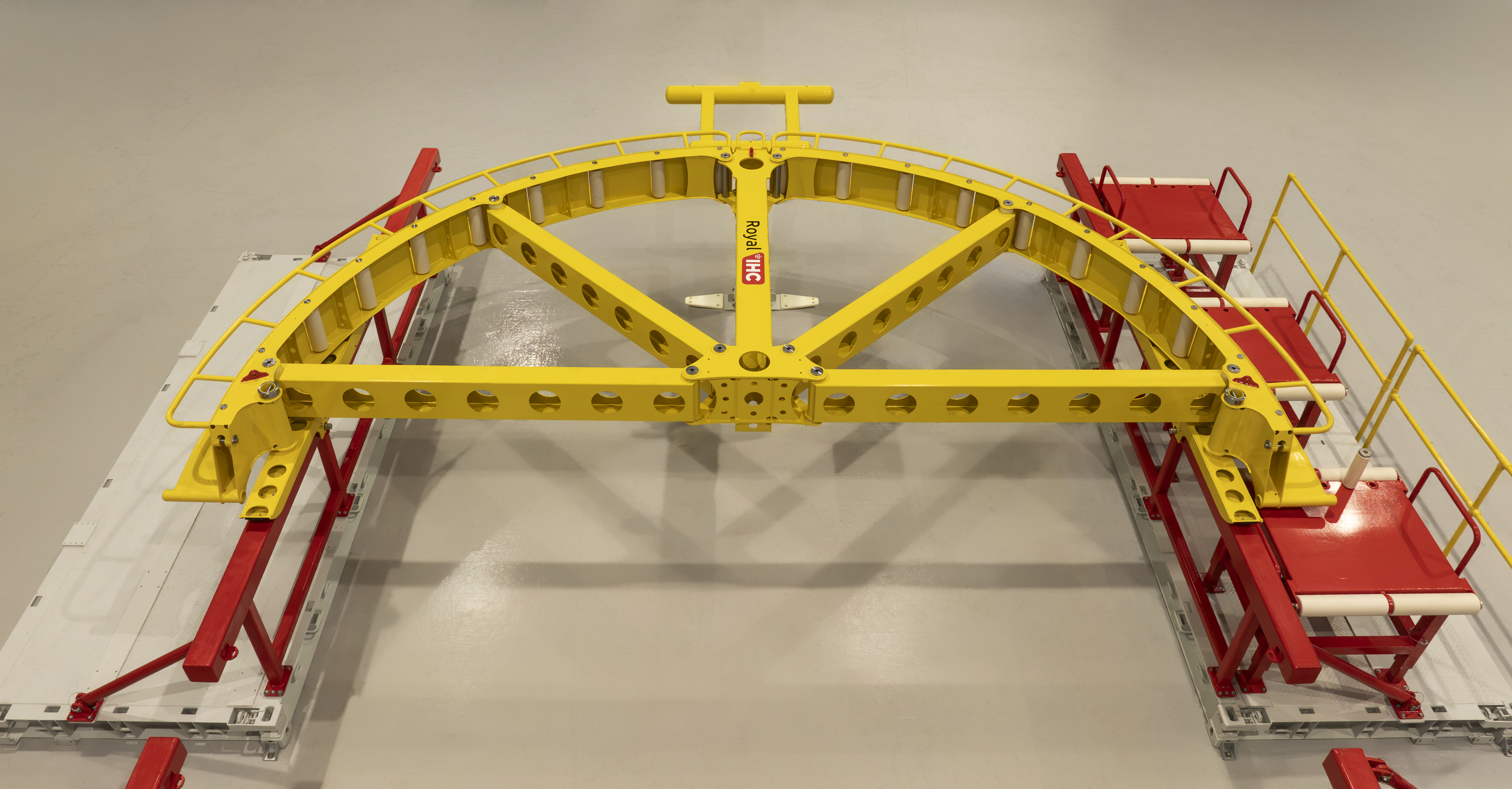 Aerial photo of a yellow quadrant and red, palletised roller tables. Laid out on a clean factory floor.