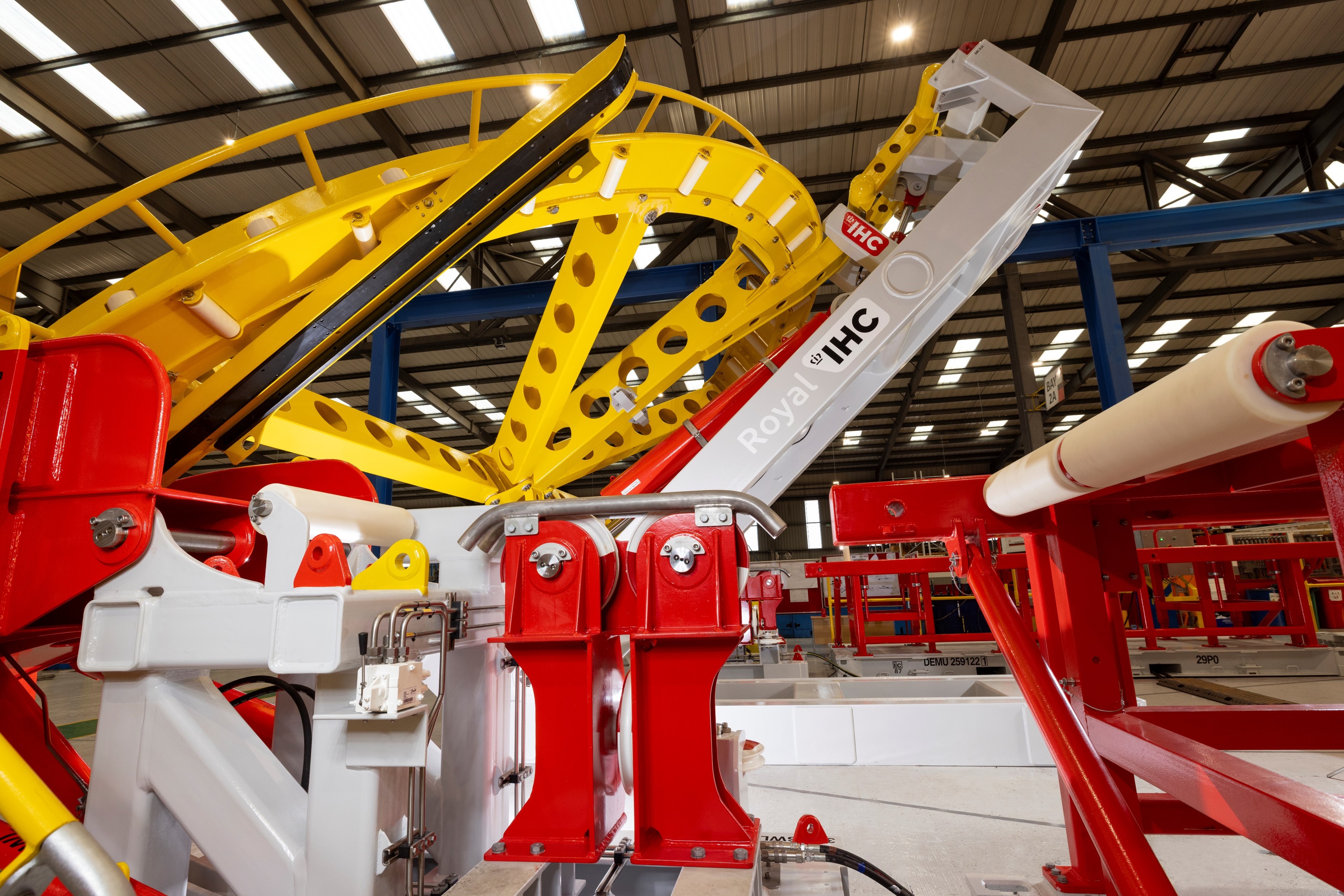 View behind of a large yellow quadrant being lifting by a red and white quadrant handling system