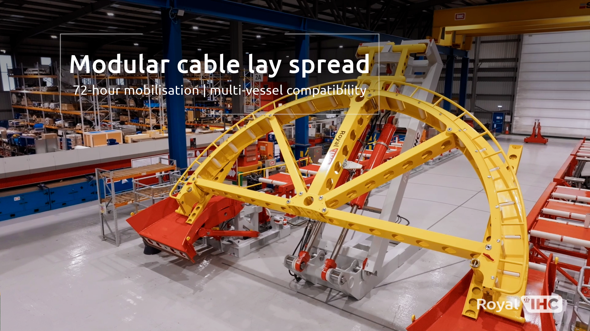 Cable lay spread with tipped yellow quadrant and red roller tables, in a clean factory setting. On-screen text: Modular Cable Lay Spread: 72 hour mobilisation, multi-vessel compatibility