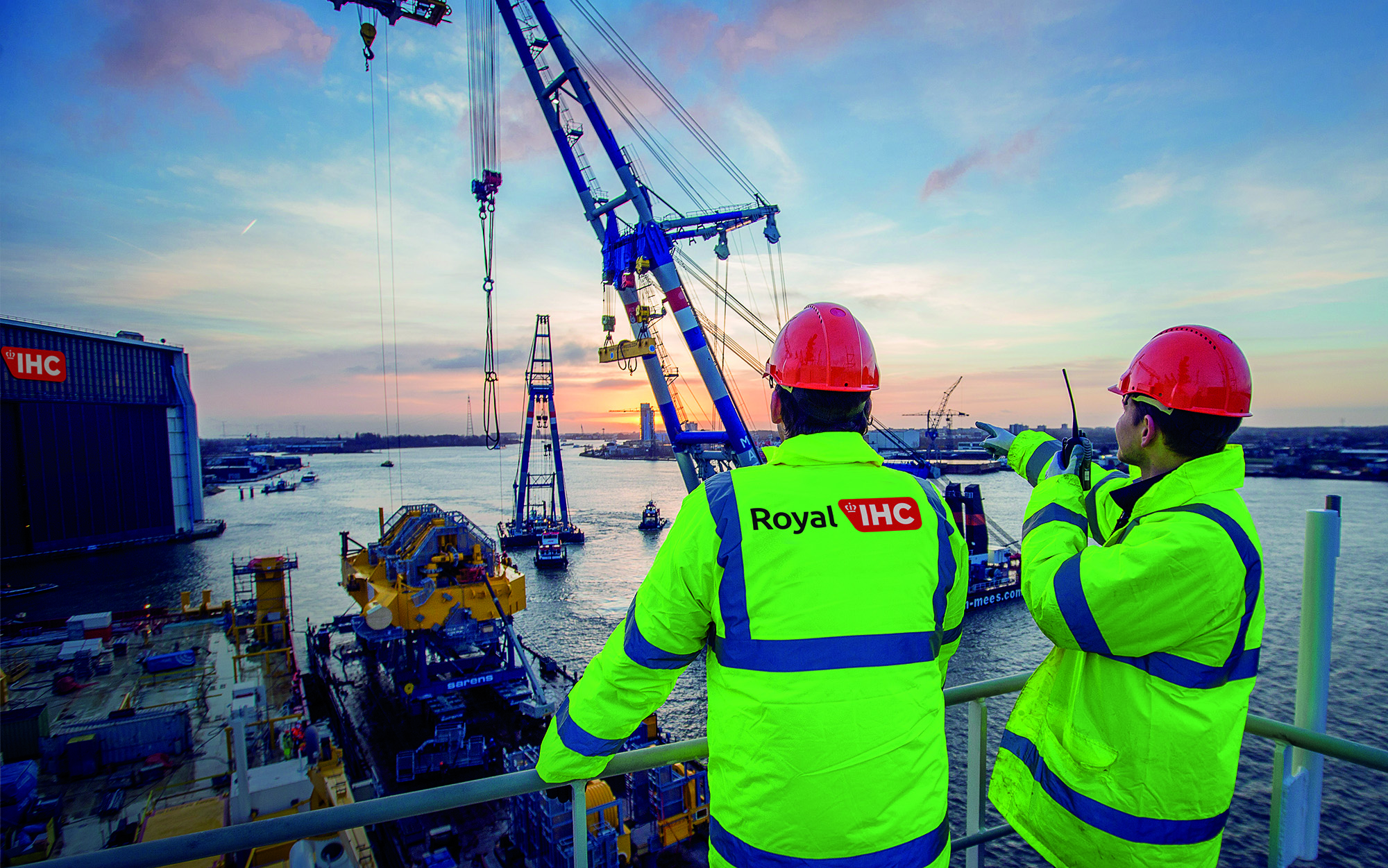 Royal IHC employees at shipyard with crane at sundown